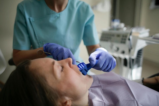 Dentist in dental office talking with female patient and preparing for treatment