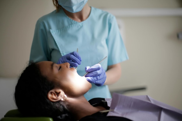 Dentist in dental office talking with female patient and preparing for treatment