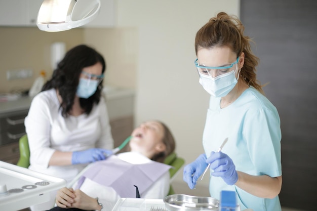 Dentist in dental office talking with female patient and preparing for treatment