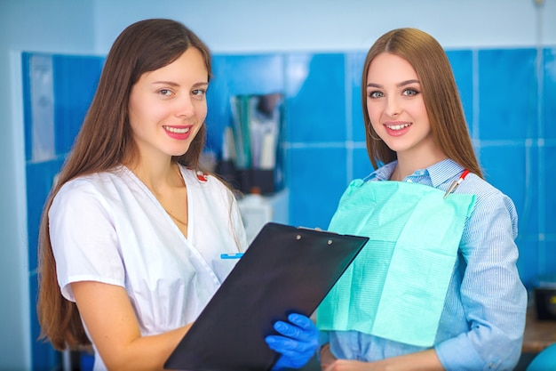 Photo dentist discussing over tablet with female patient in dental clinic