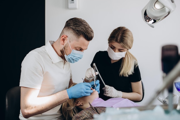 Dentist doctor and his team treating a patient at clinic