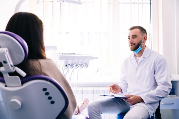 Dentist doctor at the workplace conducts a patient survey.