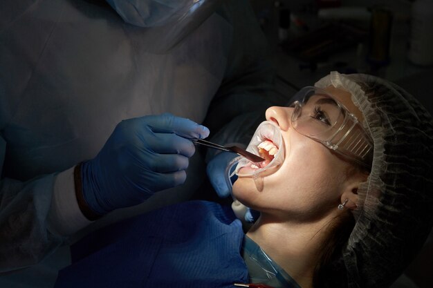 Dentist doing a dental treatment on a female patient. Dentist examining a patient's teeth in modern dentistry office