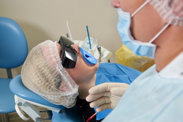 Dentist doing a dental treatment on a female patient. Dentist examining a patient's teeth in modern dentistry office