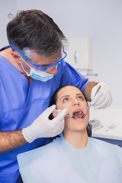 Dentist doing injection to his patient 