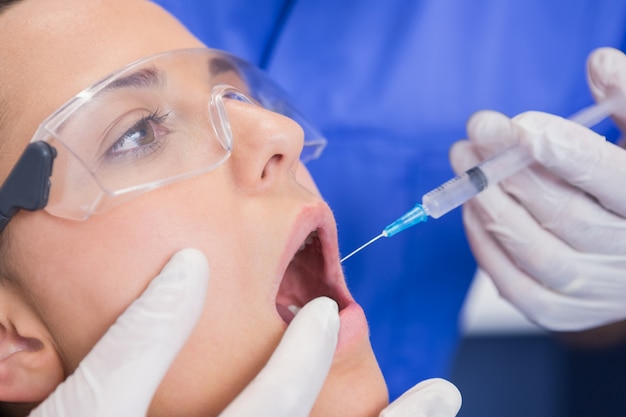 Dentist doing injection to his patient 