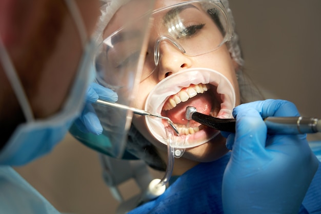 女性患者に歯を掘削する歯科医