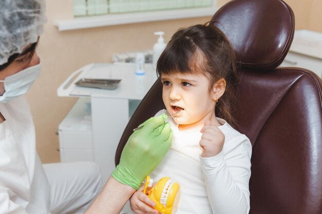 The dentist examines the child's teeth in the dental chair medicine and dentistry concept