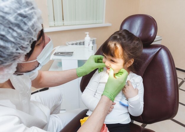 The dentist examines the child's teeth in the dental chair medicine and dentistry concept