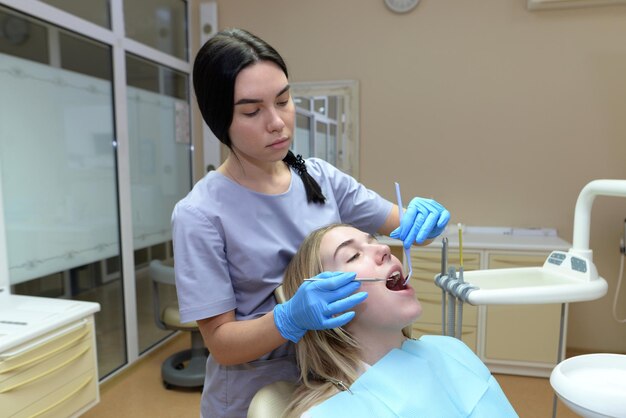 The dentist examines the patients teeth in the dental office Dental treatment