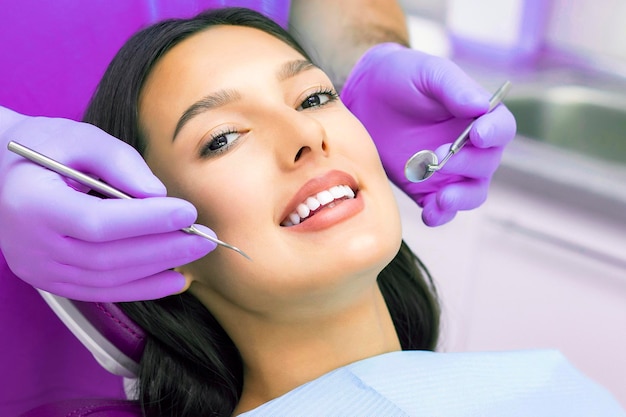 Стоматолог осматривает зубы пациентов у стоматолога
