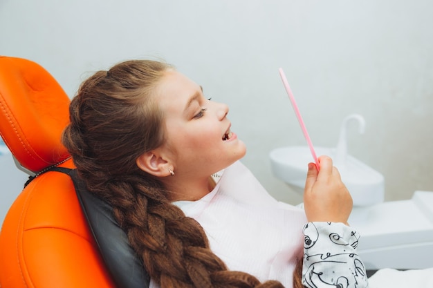 The dentist examines the teeth of a boy of 13 years old in the clinic pediatric dentistry