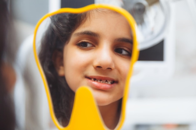 The dentist examines the teeth of a boy of 13 years old in the clinic pediatric dentistry