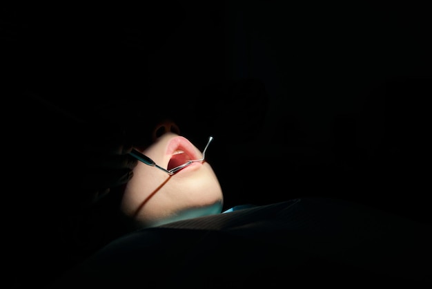 The dentist examines teeth of the child with a microscope. Professional dental equipment.