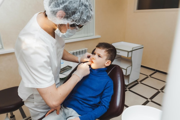 The dentist examines the teeth of a little boy a patient in a dental clinic