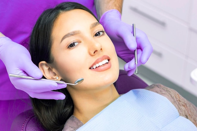 Стоматолог осматривает зубы пациентов у стоматолога
