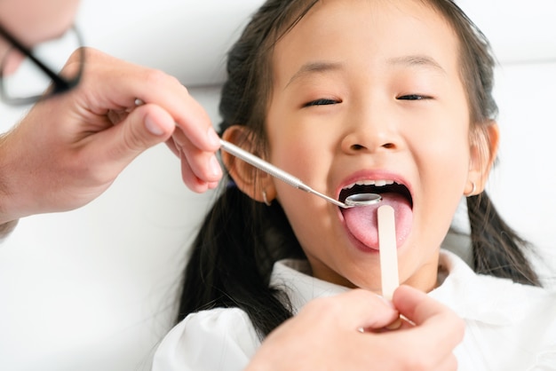 Dentist examining child teeth in dental clinic.