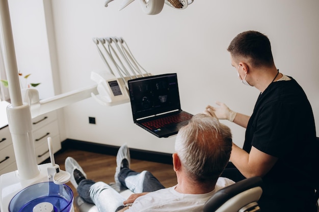 Dentist Examining Dental Xray Of Old Senior