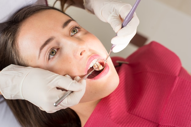 치과 의사 치과 의사 사무실에서 여성 환자의 치아를 검사