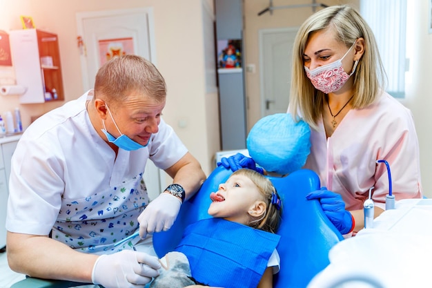 치과에서 어린 소녀의 치아를 검사하는 치과 의사
