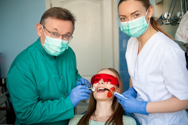歯科医は歯科医院で患者の歯を調べます。