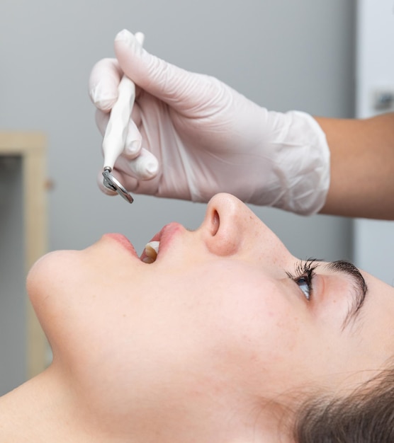 Dentist examining patient teeth with dental mirror during dental check up