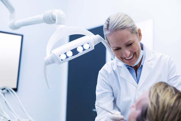 dentist examining a patient with tools