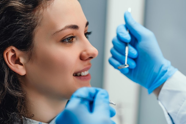 Dentist examining a patient39s teeth in the dentist Side view