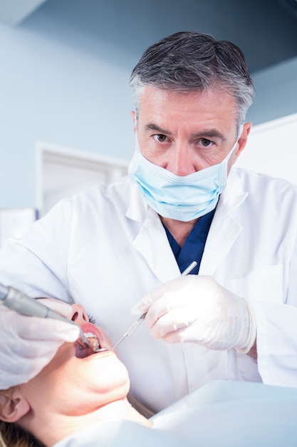 Dentist examining a patients looking at camera