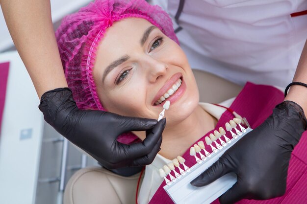 Фото Стоматолог осматривает зубы молодой пациентки в стоматологической клинике концепция стоматологии