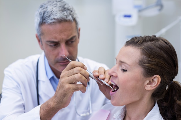 Dentista che esamina una donna con gli strumenti