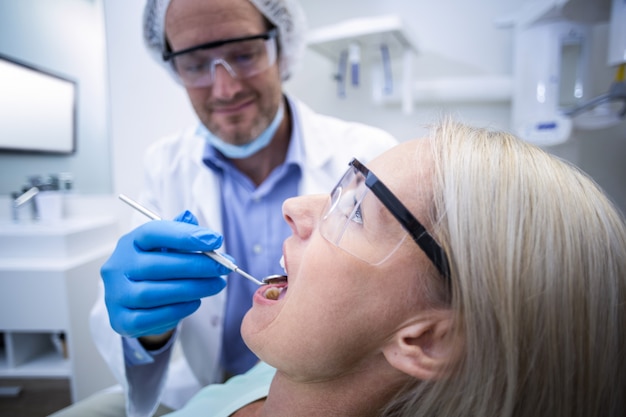 Dentist examining a woman with tools