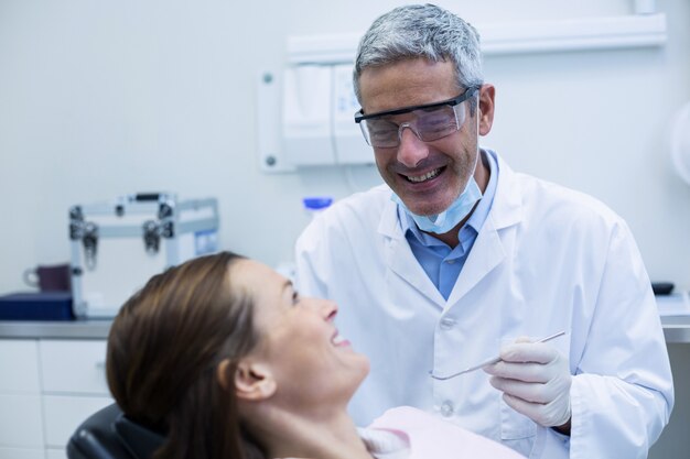 Dentist examining a young patient with tools