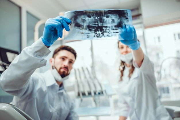 Dentist and his assistant are talking about patient39s file Selective focus