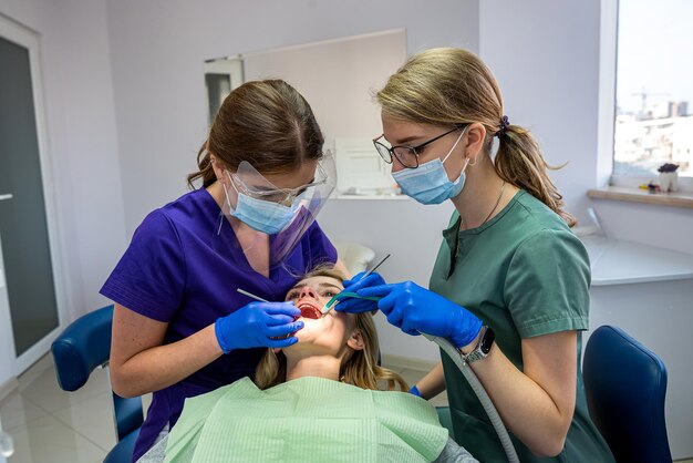 The dentist and his assistant examine the oral cavity and treat the client