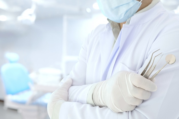 Dentist hold tools in his hand prepare to work in the room.