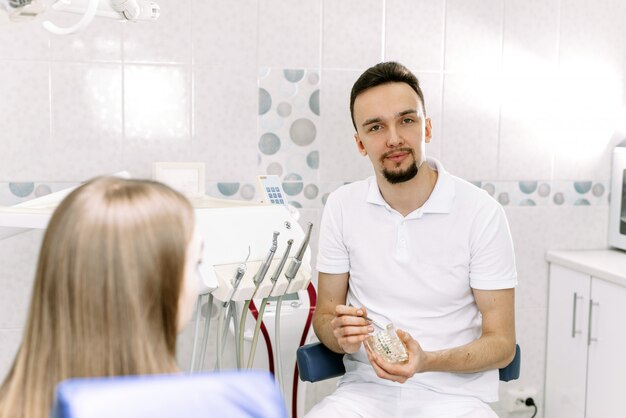 Dentist holding an artificial jaw