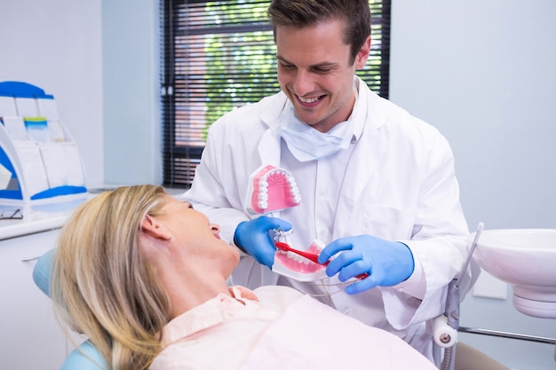 Dentista che tiene stampo dentale da donna in clinica