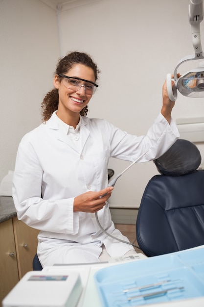 Dentist holding drill smiling at camera