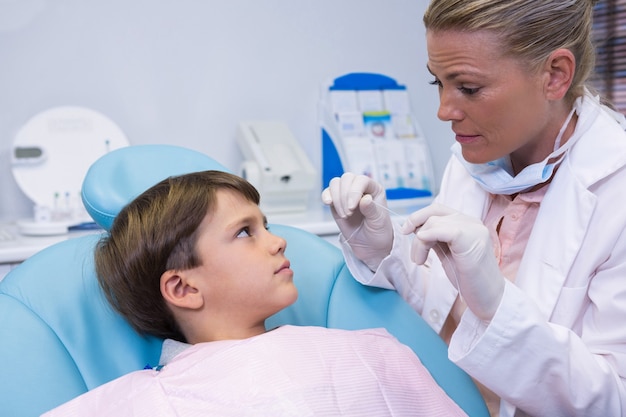소년에 게 이야기하는 동안 의료 장비를 들고 치과 의사