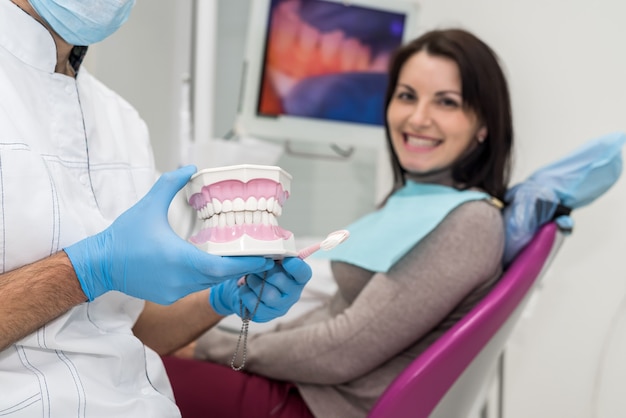 Dentista che tiene il modello della mascella in primo piano delle mani