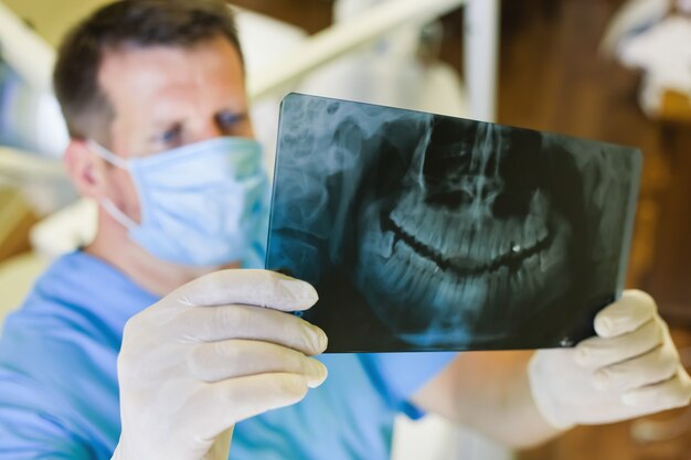 Dentist holding a picture an x-ray in his hands