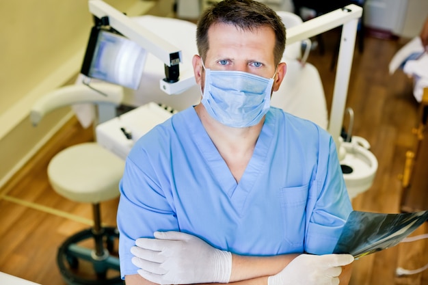 Photo dentist holding a picture an x-ray in his hands