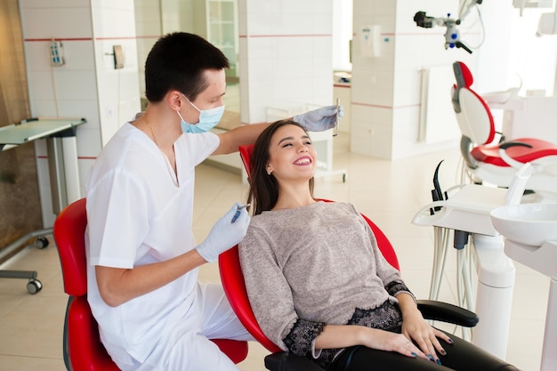 Il dentista sta curando i denti con una bella ragazza