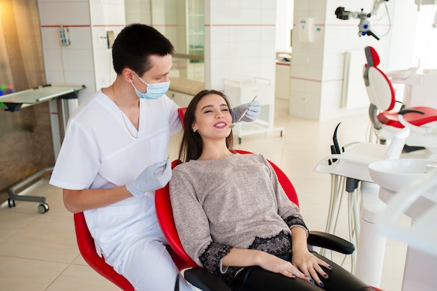 The dentist is treating teeth with a beautiful woman