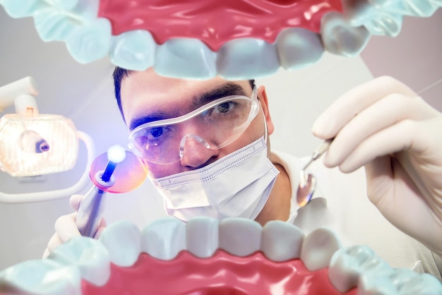Стоматолог смотрит в полость рта пациенту