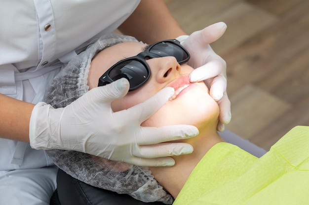 Dentist looks at a jaw of female patient checking the bite