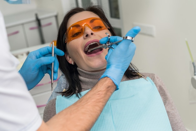 Dentist making injection of anesthetic to patient