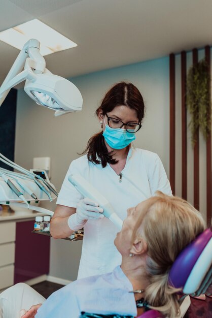 A dentist in a modern dental practice performs jaw surgery on an elderly patient. High quality photo