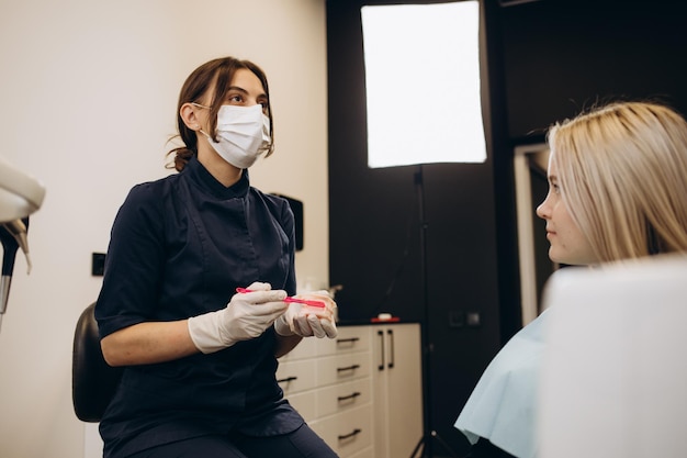 Dentist and patient choosing treatment in a consultation with medical equipment in the background